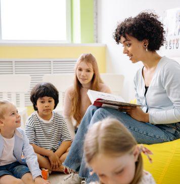Adult reading to children in a classroom.